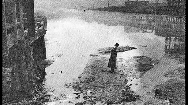 A man standing on waste in Bubbly Creek, 1911. (Wikimedia Commons)