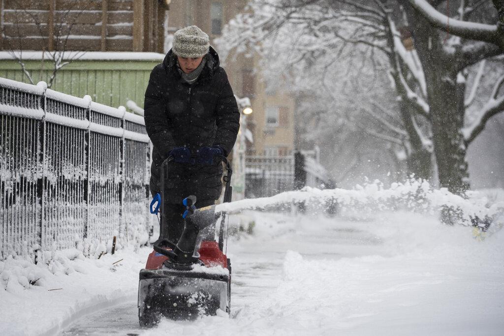 A woman plows the sidewalk near North Ridge Boulevard and West Birchwood Avenue in Rogers Park after more than 3 inches of snow fell during a winter storm that moved through the Chicago area overnight, Tuesday morning, Jan. 26, 2021. (Ashlee Rezin Garcia / Chicago Sun-Times via AP)